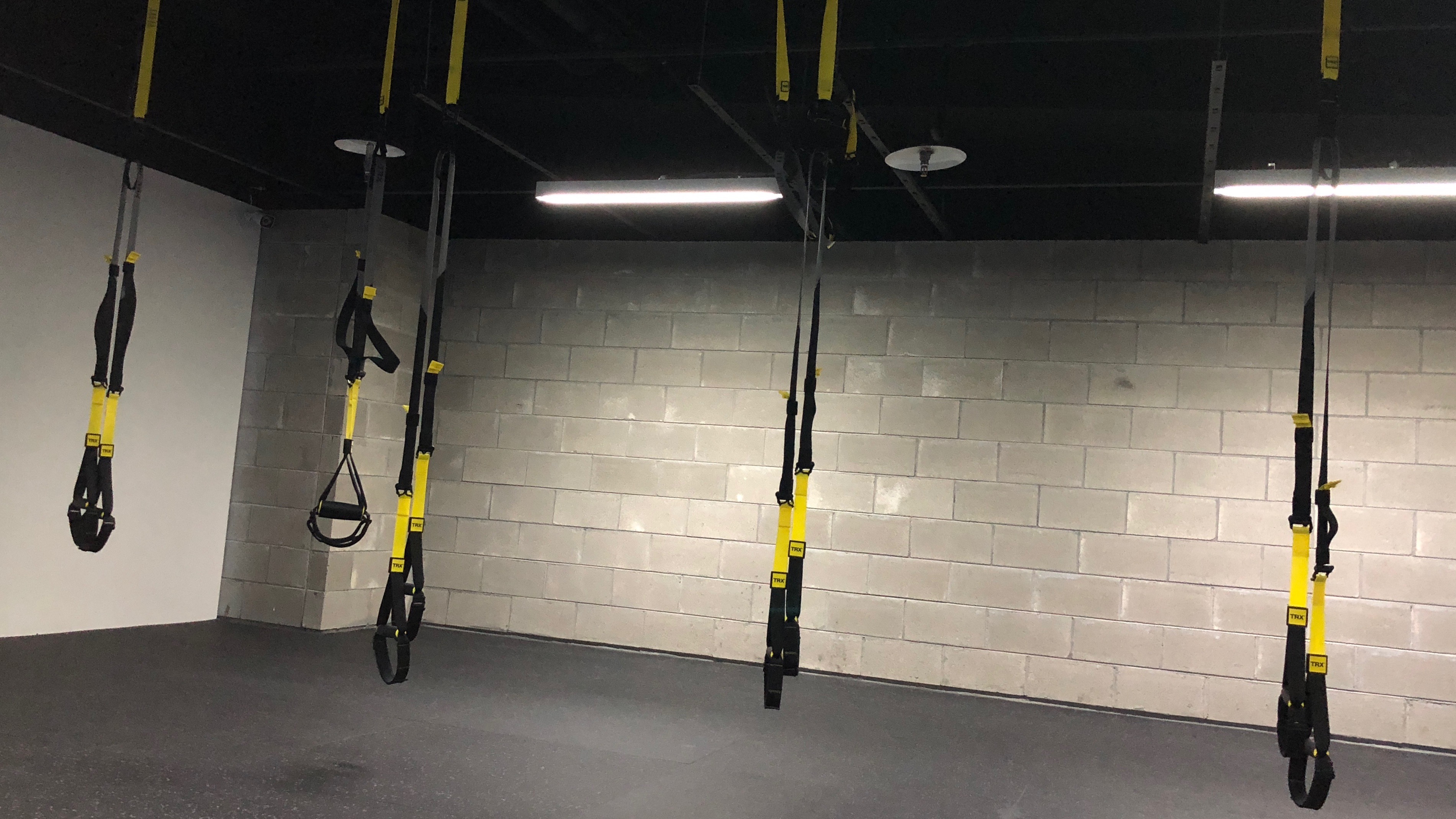 TRX教室,此組圖有五張照片,照片內容為學員學習不同動作,雙腳放在掛勾手撐地,雙手撐在掛勾身體前傾訓練平衡,還有一張是TRX繩索的照片